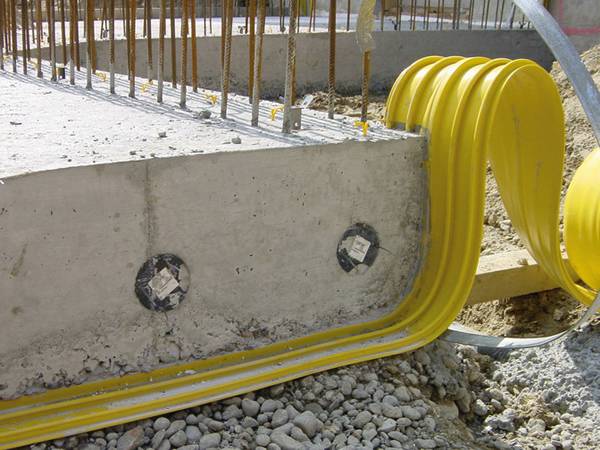 A half of yellow waterstop is embedded in the concrete after the first pour of concrete